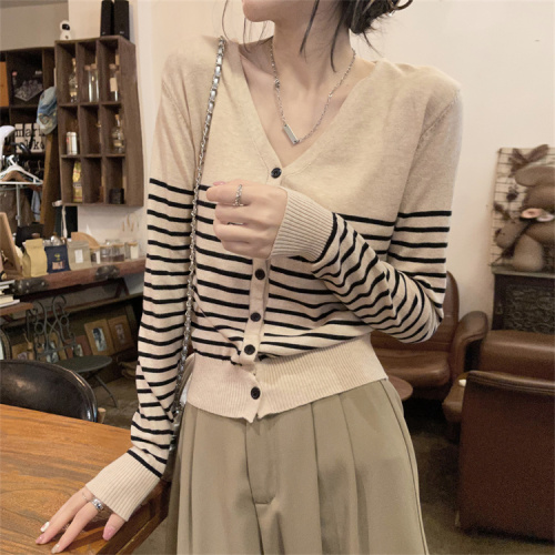 Real shot of contrasting striped V-neck knitted cardigan layered over women's autumn slim sweater jacket top