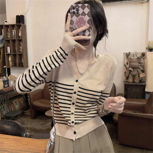 Real shot of contrasting striped V-neck knitted cardigan layered over women's autumn slim sweater jacket top
