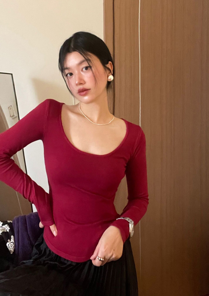Actual shot of a soft, waxy, burgundy, white, large U-neck slim-fitting long-sleeved sweater top