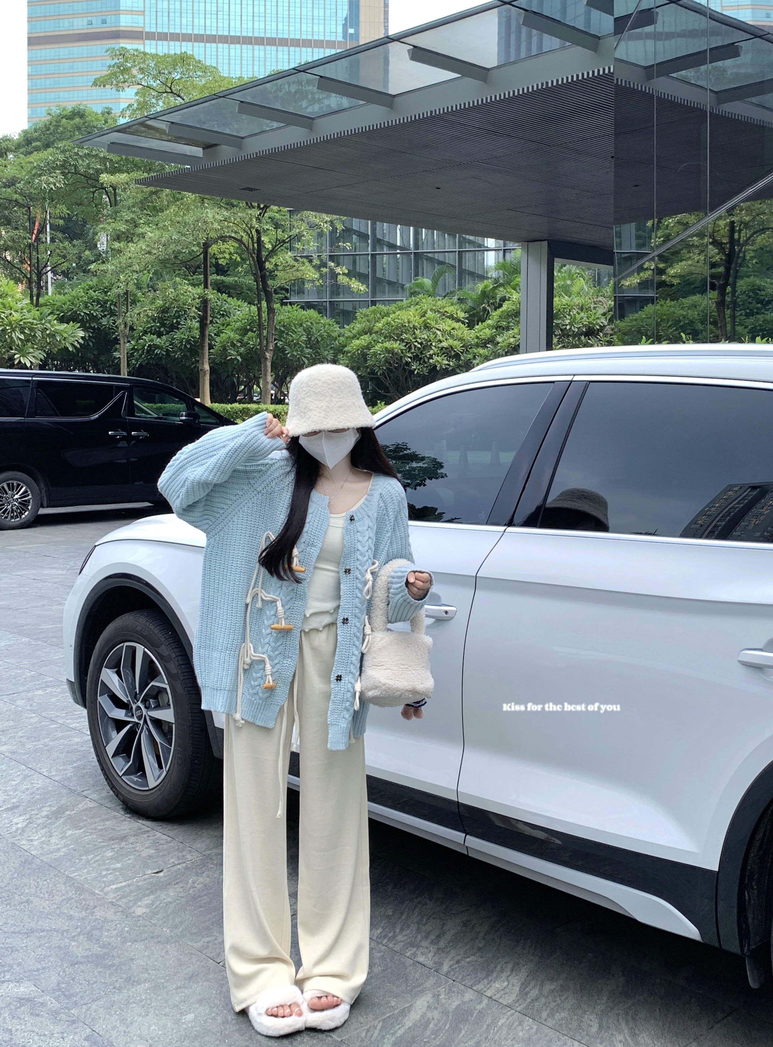 Actual shot of a milk blue horn-buttoned sweater worn outside a lazy-style round-neck coat and drapey floor-length trousers suit