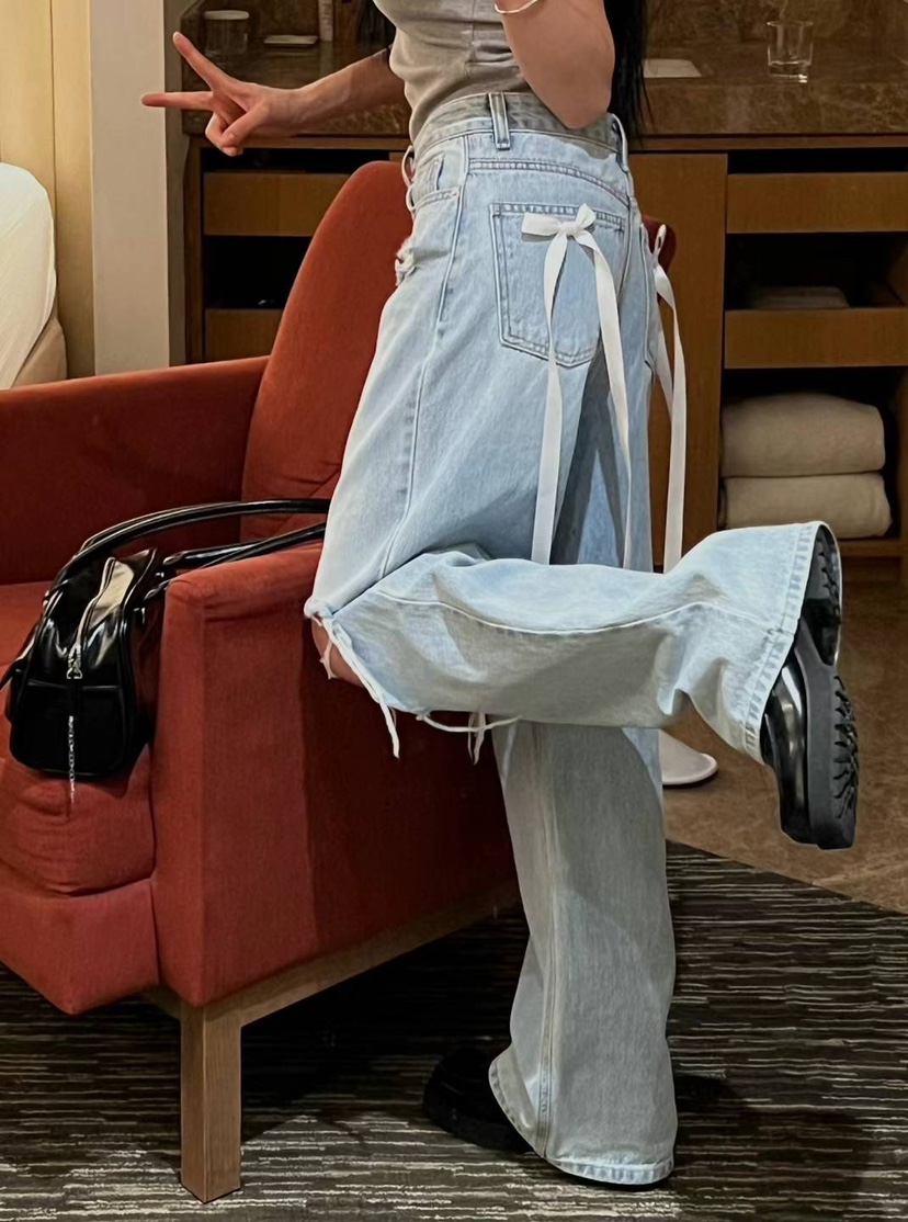 High-waisted washed ripped jeans with bow tie and ribbon