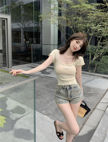 Real shot of a sweet hottie showing off her waist in a square-necked short-sleeved sweater with a stylish design and a cropped top that is tied at the back