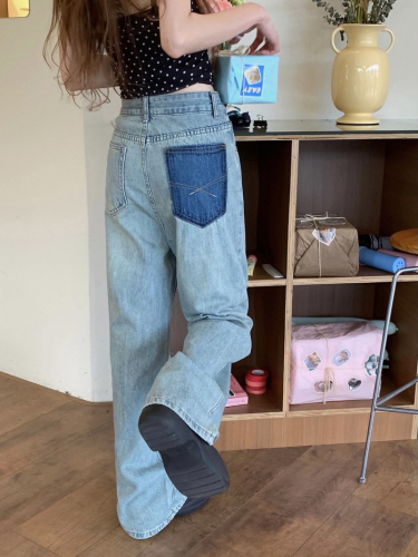 Actual shot of early spring loose wide-leg washed blue straight floor-length denim trousers