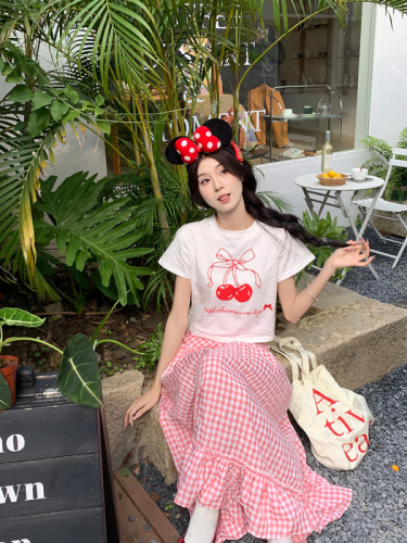 Real shot of Korean chic Xia wearing a cherry T-shirt + versatile pink plaid skirt