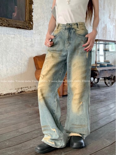 Real shot of summer retro beggar outfit, distressed ripped denim floor-length trousers for women