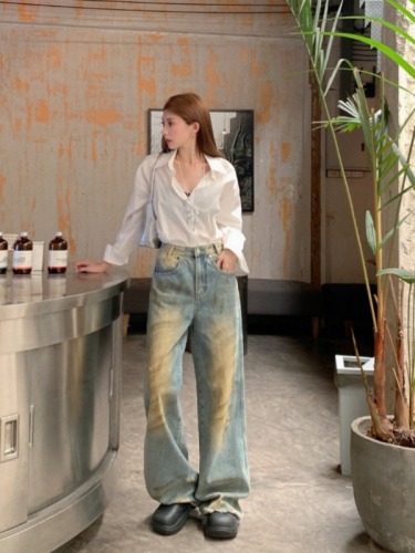 Real shot of summer retro beggar outfit, distressed ripped denim floor-length trousers for women