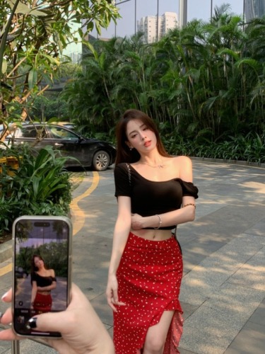 Real shot of a hot girl with a stylish floral irregular hip-hugging skirt + a short backless top with built-in breast pads