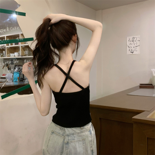 Real shot of a hot girl wearing a knitted camisole with a slim bottom and a beautiful back, wearing a sexy backless top
