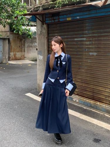 Actual shot of a little guy wearing a preppy early autumn outfit with a fake two-piece top + a versatile skirt