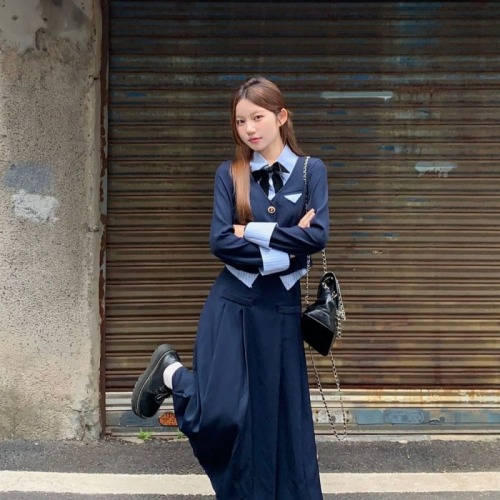 Actual shot of a little guy wearing a preppy early autumn outfit with a fake two-piece top + a versatile skirt