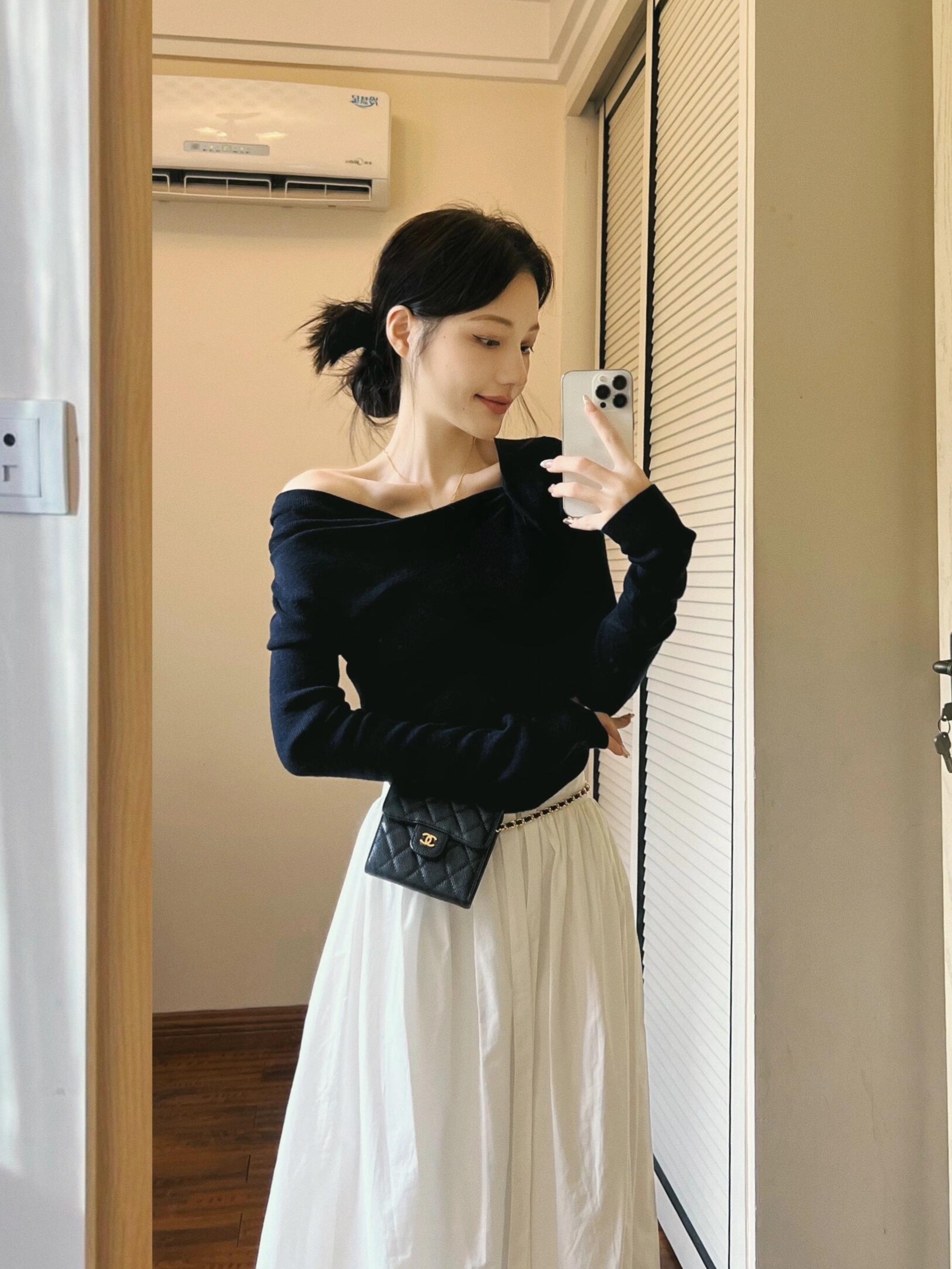 A complete autumn outfit with Korean chic style, featuring a black off-shoulder top and a white skirt, creating a salty-light mature two-piece set.