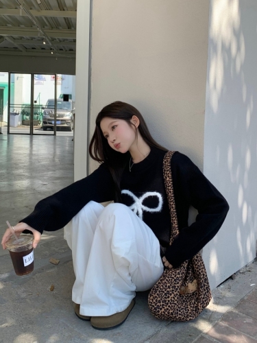 Real shot of black pullover sweater with bow for women in autumn and winter, lazy design knitted top