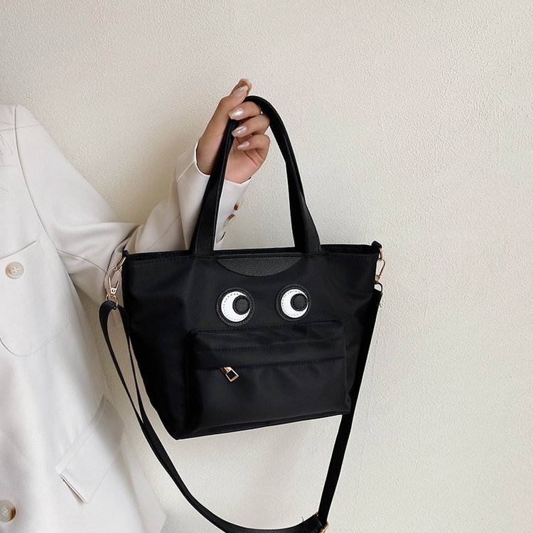Textured cowhide hand-held dumpling bag for women, new style, cute smiling face, lightweight and versatile nylon cloth foreign trade shoulder crossbody bag