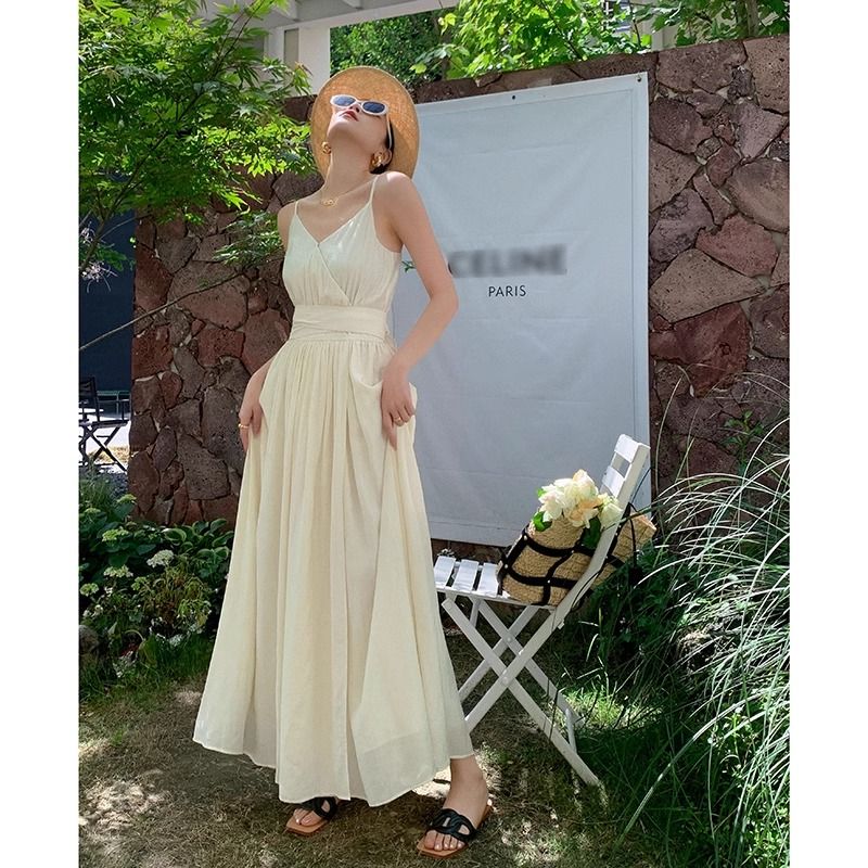 高級感輕奢名媛淺杏色吊帶連衣裙夏季2025新款收腰顯瘦度假長裙子