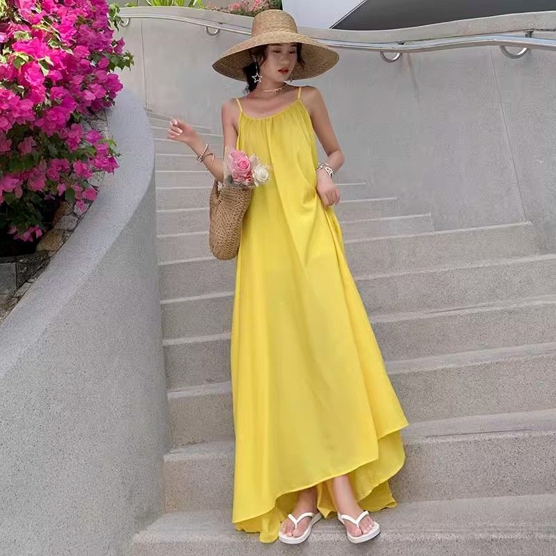 海邊度假性感露背吊帶連衣裙女夏季新款寬鬆a字裙溫柔黃色長裙子