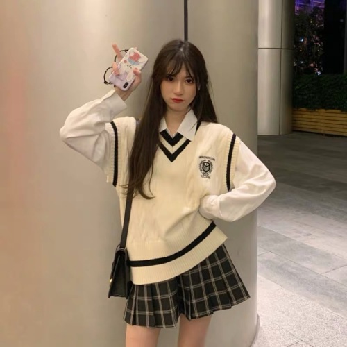 Quality inspector's photo of a small man with a college style vest, a white shirt, a plaid pleated skirt, and a two-piece suit for age reduction.