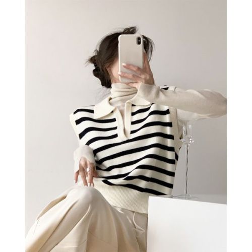 To go to the brightly lit, milky white background with black stripes neatly layered on a V-neck knitted vest vest